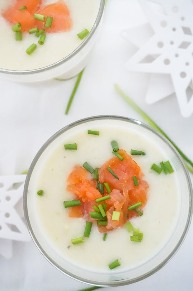 Romige pastinaaksoep met zalmsnippers en bieslook, geserveerd als licht en feestelijk kerst voorgerecht in een glaasje of kom.
