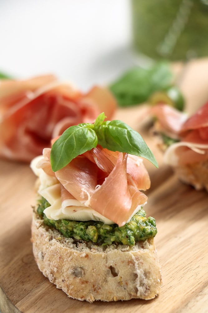 Crostini met pesto, brie en rauwe ham op knapperig stokbrood, feestelijk borrelhapje.