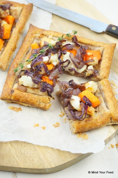 Hartige bladerdeegtaartjes gevuld met pompoen, geitenkaas, champignons en gekarameliseerde ui, feestelijk geserveerd als warm kerst voorgerecht.