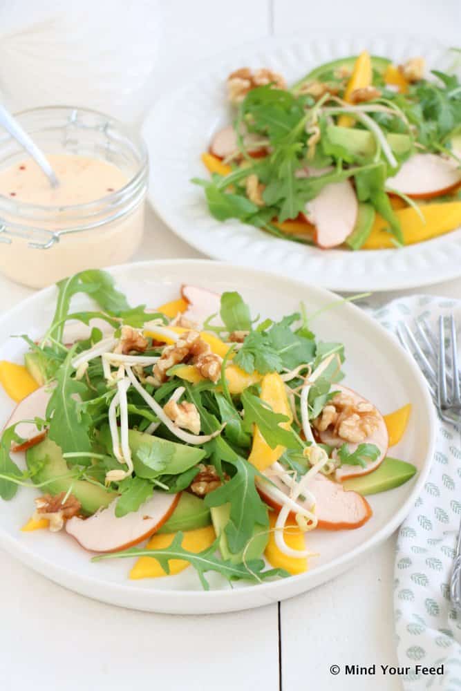 Frisse salade met gerookte kip, mango, avocado, rucola en chilidressing als feestelijk voorgerecht voor Kerst.