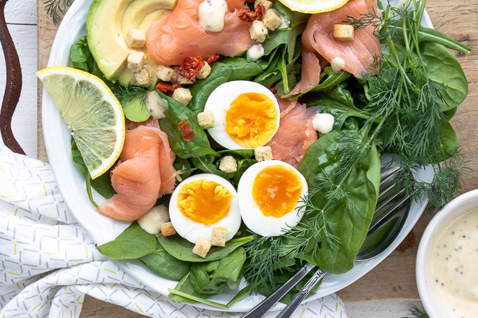 Salade met gerookte zalm, spinazie, avocado en gekookt ei. Makkelijk recept voor lunch salade met zelfgemaakte honing mosterd dressing