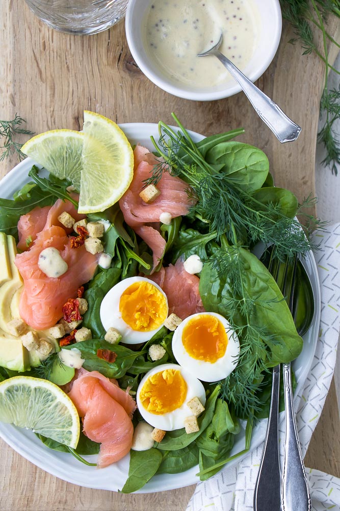 Salade met gerookte zalm, spinazie, avocado en gekookt ei. Makkelijk recept voor lunch salade met zelfgemaakte honing mosterd dressing