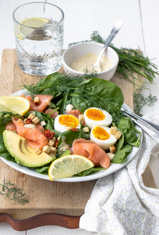 Salade met gerookte zalm, spinazie, avocado en gekookt ei. Makkelijk recept voor lunch salade met zelfgemaakte honing mosterd dressing