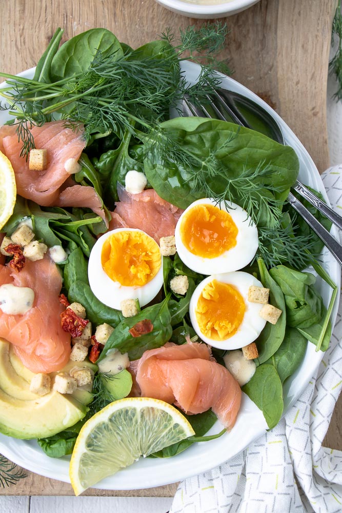 Salade met gerookte zalm, spinazie, avocado en gekookt ei. Makkelijk recept voor lunch salade met zelfgemaakte honing mosterd dressing