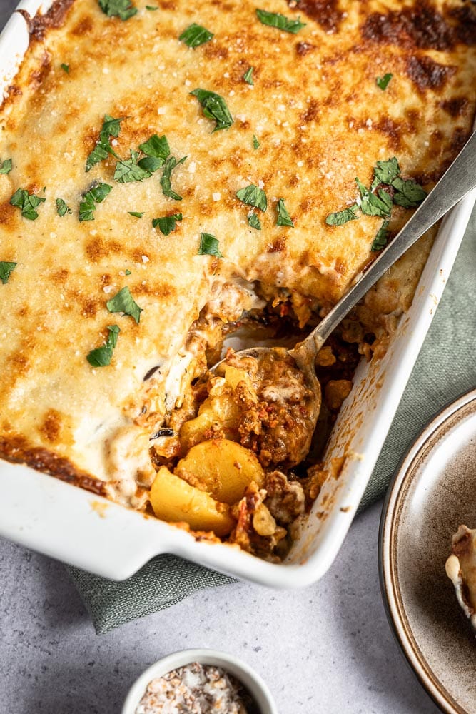 Recept voor klassieke Griekse Moussaka: Heerlijke kruidige tomatensaus met gehakt, rijkelijk gekruid met mediterrane kruiden, die deze moussaka zijn onmiskenbare smaak geeft.