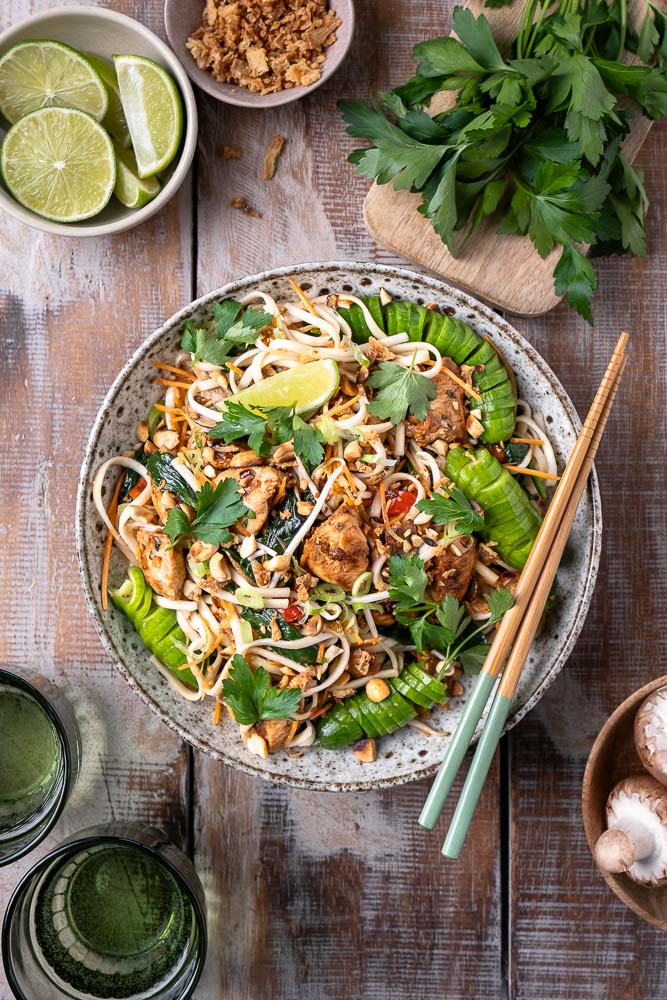 Noedels met kip en groenten, een lekker en makkelijk recept uit de Aziatische keuken van roerbak noodles of noedels met kip in Oosterse marinade met verschillende roerbakgroenten zoals wortel, spinazie, paprika en tauge in een kruidige Hoisin saus. 