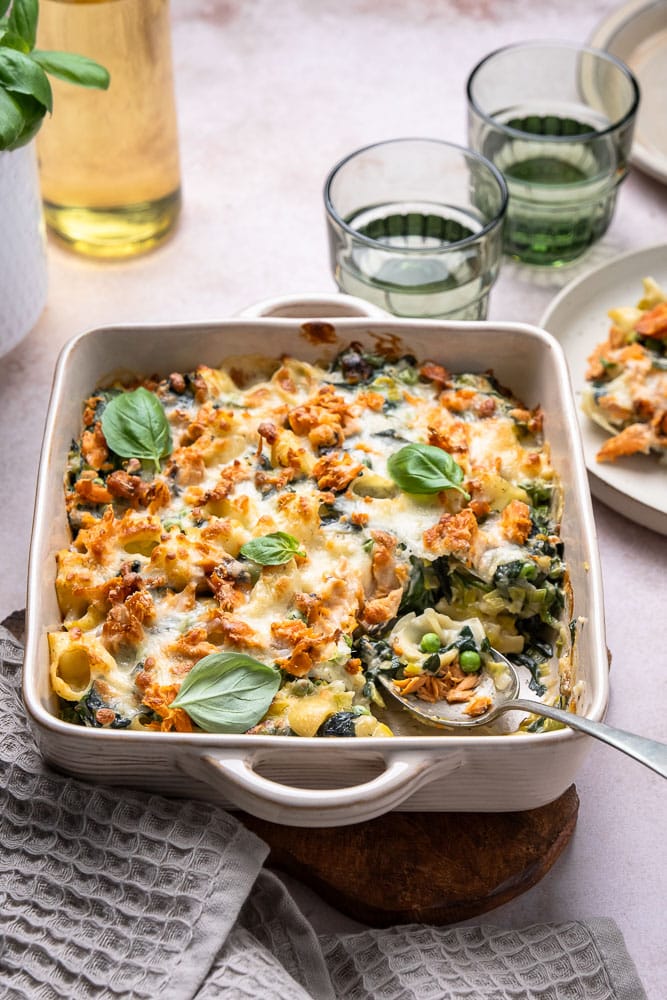 Pasta ovenschotel met zalm, een heerlijk en makkelijk recept voor een pastaschotel uit de oven. Deze pasta ovenschotel met zalm, spinazie, prei en doperwten en een heerlijke roomsaus komt zeker in het lijstje met onze nieuwe favoriete pasta recepten!