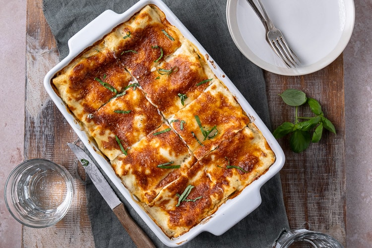 Lasagne met zalm en spinazie, romige zalm lasagne met spinazie, prei, ricotta, mozzarella en bechamelsaus. Lekker en simpel recept om zelf lasagne met zalm te maken.