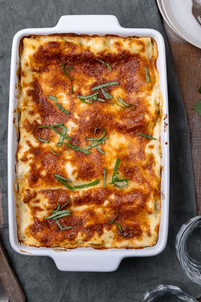 Lasagne met zalm en spinazie, romige zalm lasagne met spinazie, prei, ricotta, mozzarella en bechamelsaus. Lekker en simpel recept om zelf lasagne met zalm te maken.