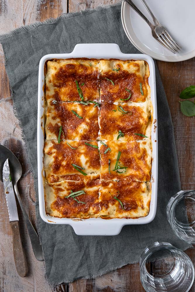 Lasagne met zalm en spinazie, romige zalm lasagne met spinazie, prei, ricotta, mozzarella en bechamelsaus. Lekker en simpel recept om zelf lasagne met zalm te maken.