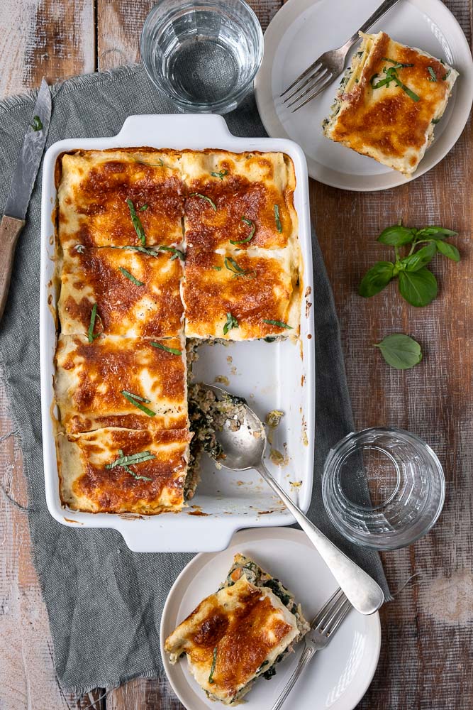 Lasagne met zalm en spinazie, romige zalm lasagne met spinazie, prei, ricotta, mozzarella en bechamelsaus. Lekker en simpel recept om zelf lasagne met zalm te maken.