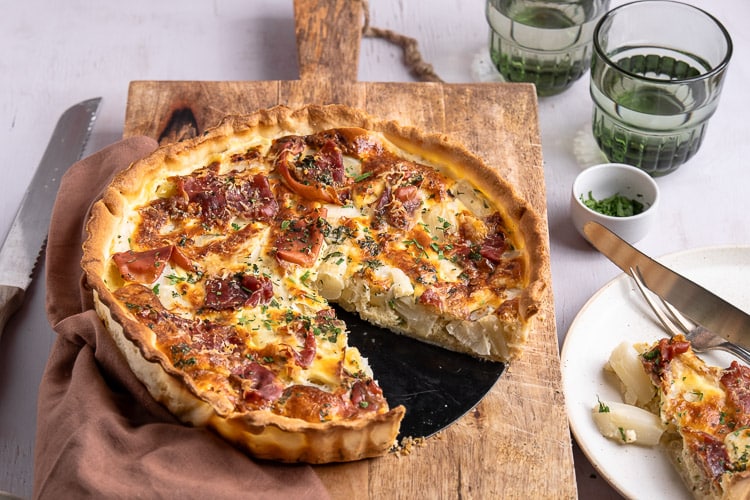 Wat een plaatje, deze quiche met witte asperges en ham! Echt zo'n heerlijk gerecht voor in het voorjaar en nu het aspergeseizoen weer is geopend, kan ik geen genoeg krijgen van het witte goud. Met deze lichte quiche met asperges haal je zo het zonnetje in huis! Dit makkelijke recept voor quiche met asperges is echt een feestje waar iedereen van smult.