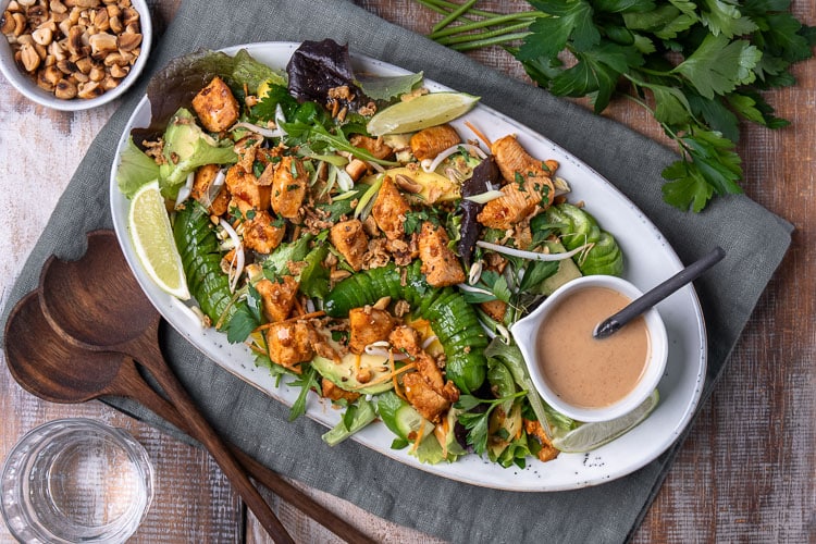 Dit recept voor salade met pittige kip gaat ongetwijfeld jouw favoriete maaltijdsalade van deze zomer worden! Een goedgevulde salade met Oosterse smaken van frisse komkommer, zoete mango, knapperige taugé en stukjes hete kip. En een zelfgemaakte pindadressing!