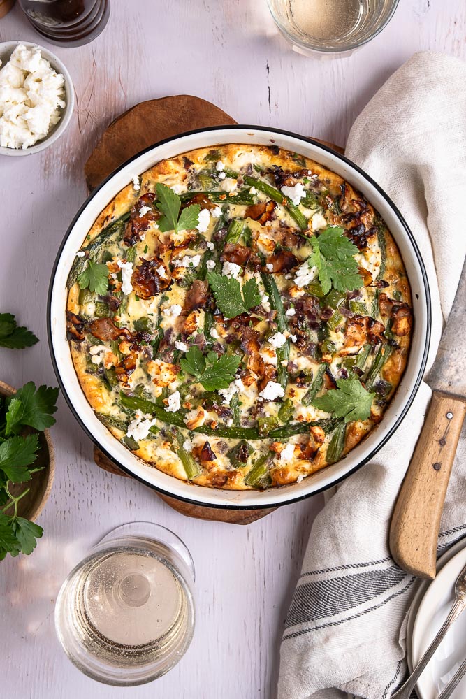 Een heerlijk hartig ontbijtje, een lekkere uitgebreide lunch of een makkelijke en lichte avondmaaltijd... Deze frittata uit de oven met groene asperges en feta kan elk moment op tafel gezet worden. Met dit makkelijke recept voor frittata kom je ook nog eens eenvoudig aan je dagelijkse portie groenten. Dit ovengerecht is daarom wat mij betreft nu al een winnaar!
