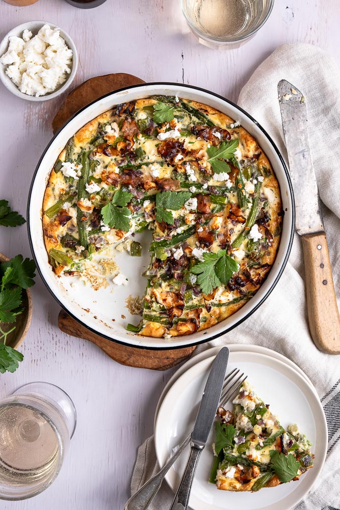 Een heerlijk hartig ontbijtje, een lekkere uitgebreide lunch of een makkelijke en lichte avondmaaltijd... Deze frittata uit de oven met groene asperges en feta kan elk moment op tafel gezet worden. Met dit makkelijke recept voor frittata kom je ook nog eens eenvoudig aan je dagelijkse portie groenten. Dit ovengerecht is daarom wat mij betreft nu al een winnaar!