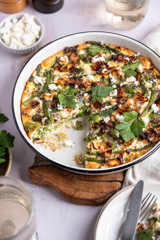 Een heerlijk hartig ontbijtje, een lekkere uitgebreide lunch of een makkelijke en lichte avondmaaltijd... Deze frittata uit de oven met groene asperges en feta kan elk moment op tafel gezet worden. Met dit makkelijke recept voor frittata kom je ook nog eens eenvoudig aan je dagelijkse portie groenten. Dit ovengerecht is daarom wat mij betreft nu al een winnaar!