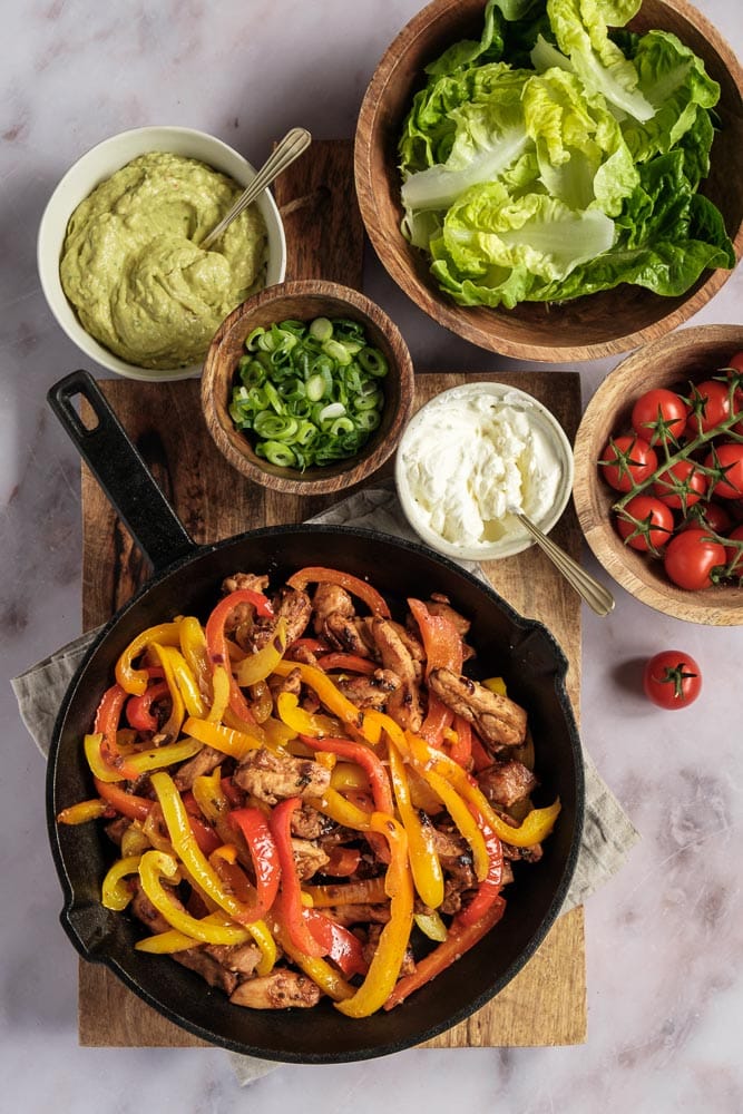Kip fajitas in sla wraps met paprika, ui en kipreepjes – lichte, koolhydraatarme Tex Mex maaltijd, perfect als gezonde zomerse avondmaaltijd.”