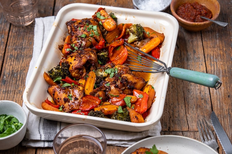 Kippendijen uit de oven in Oosterse marinade van ketjap, knoflook en sesamolie, gegaard in de oven met groenten – ideaal als koolhydraatarm ovengerecht.