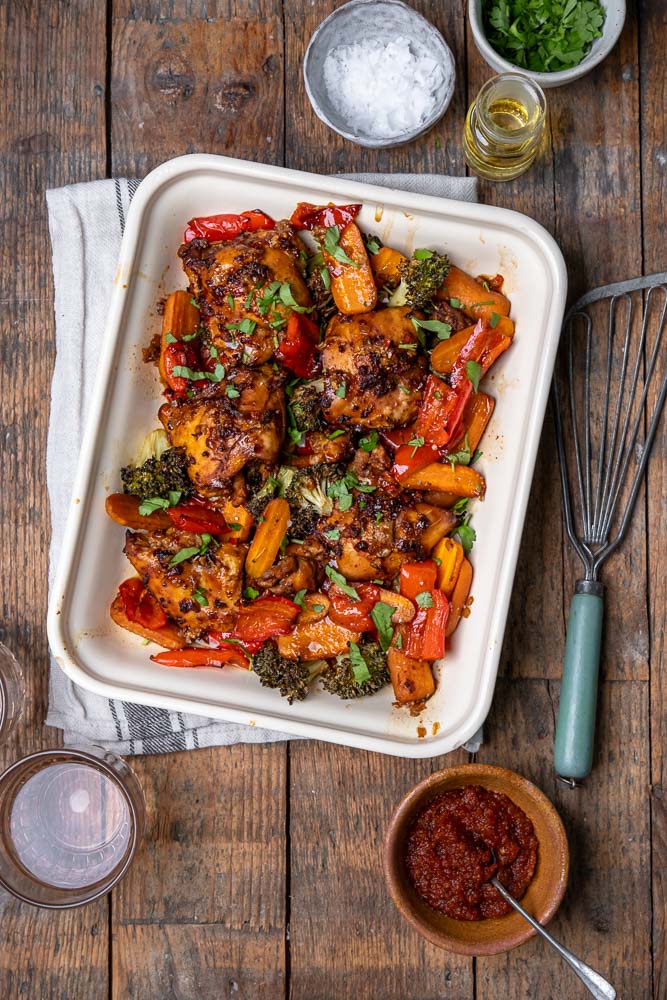 Kippendijen uit de oven in Oosterse marinade van ketjap, knoflook en sesamolie, gegaard in de oven met groenten – ideaal als koolhydraatarm ovengerecht.