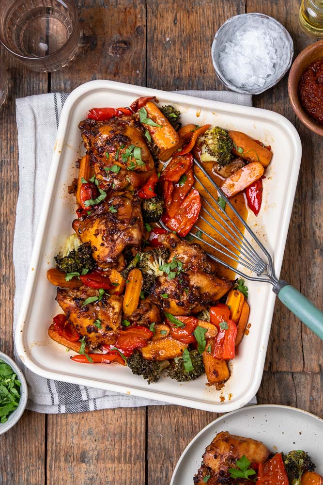 Kippendijen uit de oven in Oosterse marinade van ketjap, knoflook en sesamolie, gegaard in de oven met groenten – ideaal als koolhydraatarm ovengerecht.