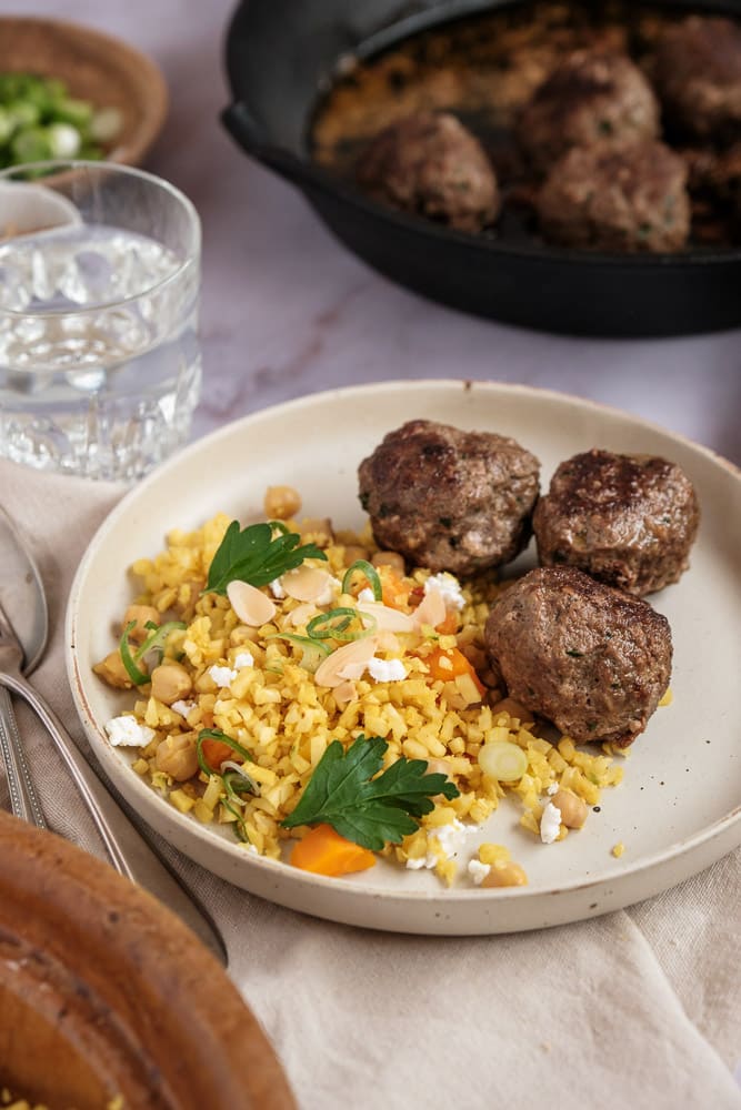 Marokkaanse gehaktballetjes met ras el hanout, komijn en koriander – kruidige balletjes geserveerd met bloemkoolcouscous, perfect als borrelhapje of avondmaaltijd.