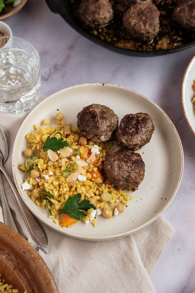 Marokkaanse gehaktballetjes met ras el hanout, komijn en koriander – kruidige balletjes geserveerd met bloemkoolcouscous, perfect als borrelhapje of avondmaaltijd.