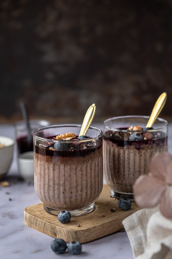 Romige chia pudding met chiazaad en plantaardige melk, gemaakt volgens een chia pudding recept met cacaopoeder, blauwe bessen en walnoten, een voedzaam ontbijt en een perfect voorbeeld van overnight chia pudding.