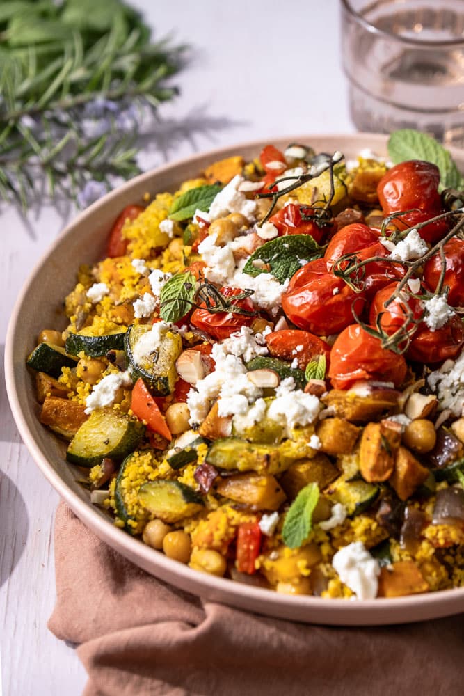 Kleurrijke couscous salade met feta, geroosterde groenten en frisse kruiden – perfecte zomerse lunch of maaltijd voor buiten.