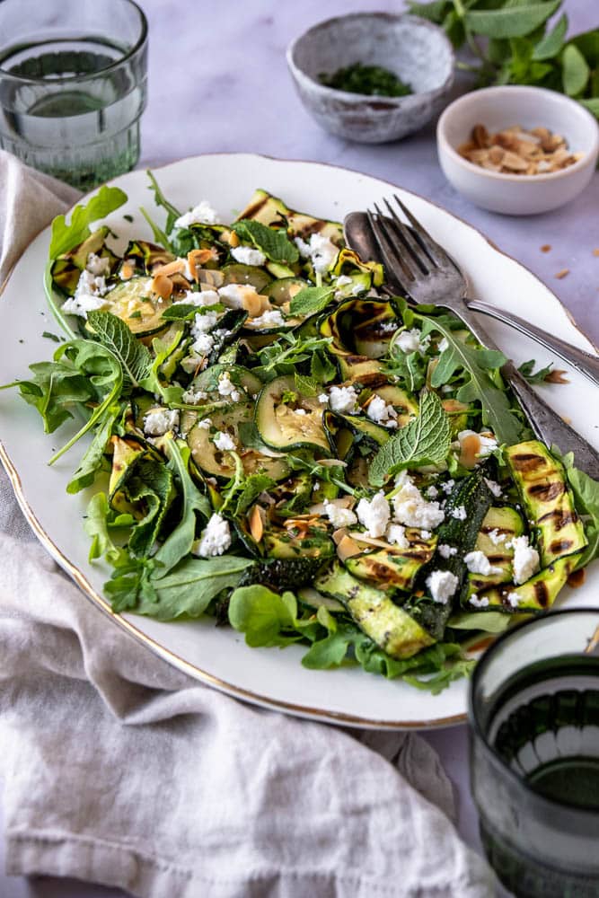 Gegrilde courgette salade met feta en rucola – frisse en gezonde salade met munt, citroen en geroosterd amandelschaafsel. Perfect als bijgerecht, salade met gegrilde courgette. 