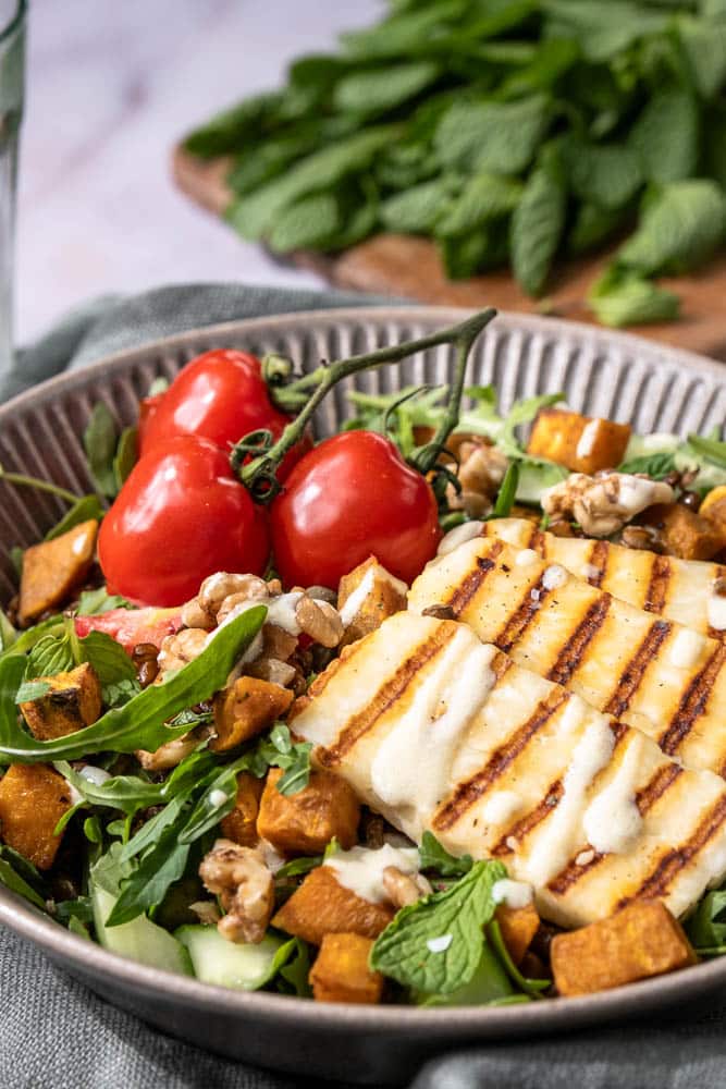 Linzen salade met halloumi, geroosterde zoete aardappel en frisse rauwkost – een gezonde, eiwitrijke lunch zonder brood.