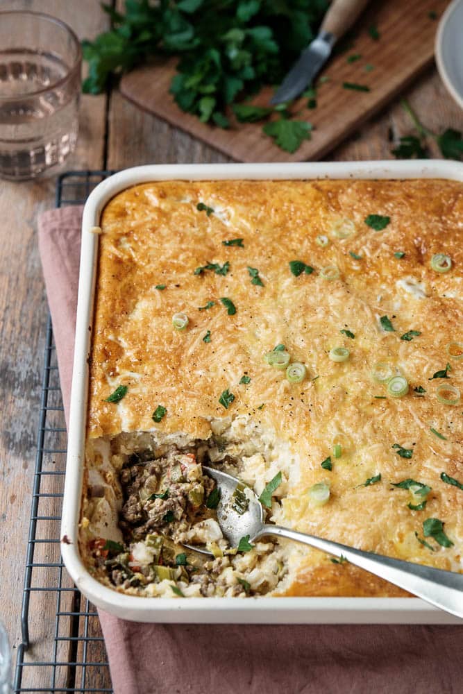 Prei ovenschotel met gehakt en kerrie in een ovenschaal met romige puree van pastinaak en knolselderij en gesmolten kaas. Eiwitrijk, laag in koolhydraten, gehakt prei ovenschotel koolhydraatarm.