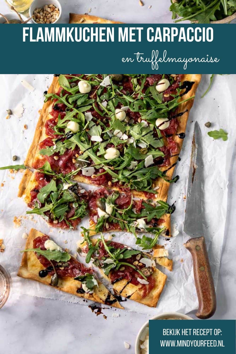 Flammkuchen met carpaccio, rucola en Parmezaanse kaas op een dunne, krokante bodem; feestelijk borrelhapje voor kerst of Oud & Nieuw.