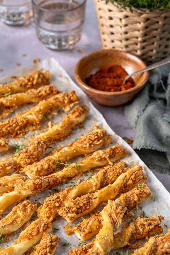 Kaasstengels maken van bladerdeeg: zelfgemaakte kaasstengels met oude kaas, Parmezaan en kruiden, krokant gebakken.