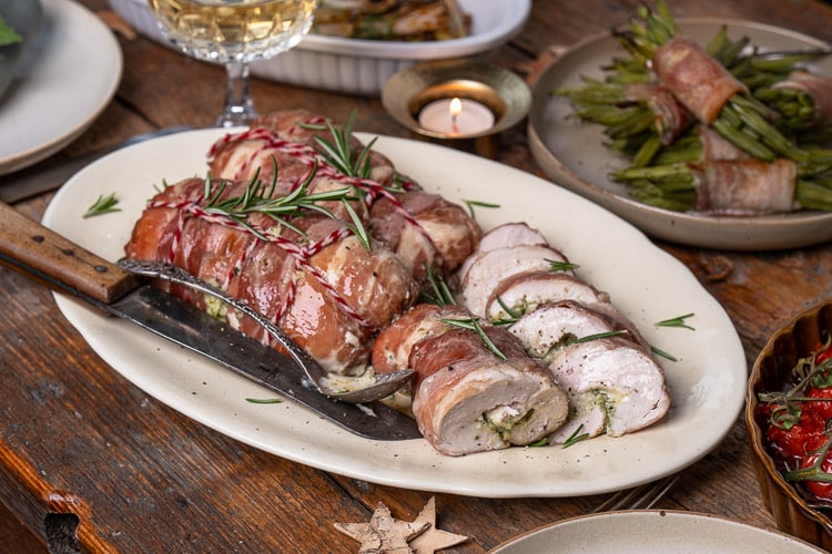 Kip rollade met pesto en prosciutto, sappig uit de oven gebakken en perfect als feestelijk hoofdgerecht met Kerst. Zelf kip rollade maken is eenvoudig, lekker met groenten erbij.