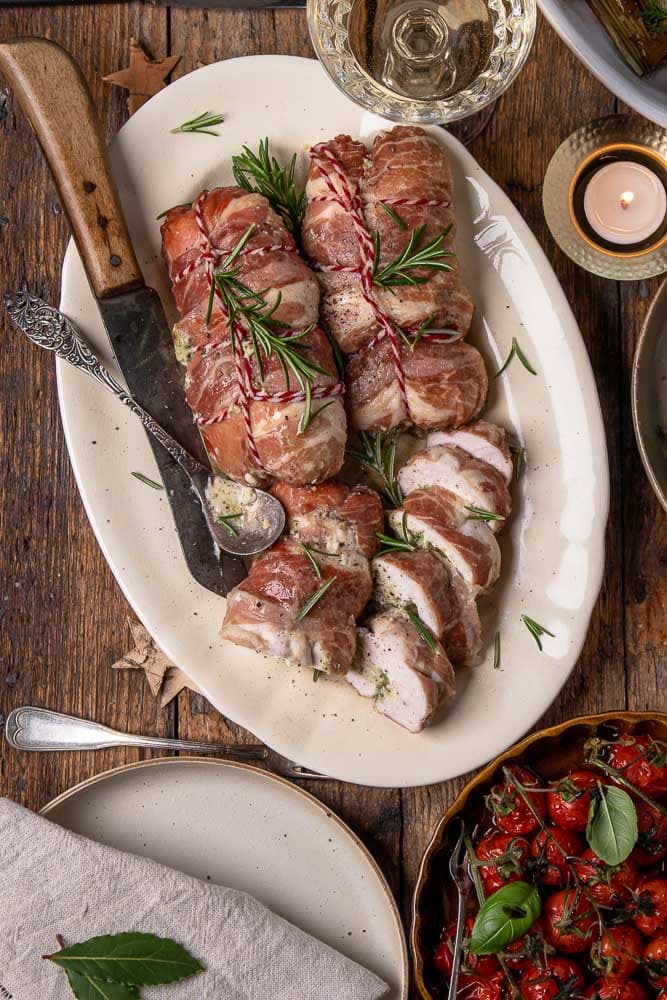 Opgerolde kipfilet met pesto en mascarpone, ingepakt in prosciutto en na het bakken in plakken gesneden.