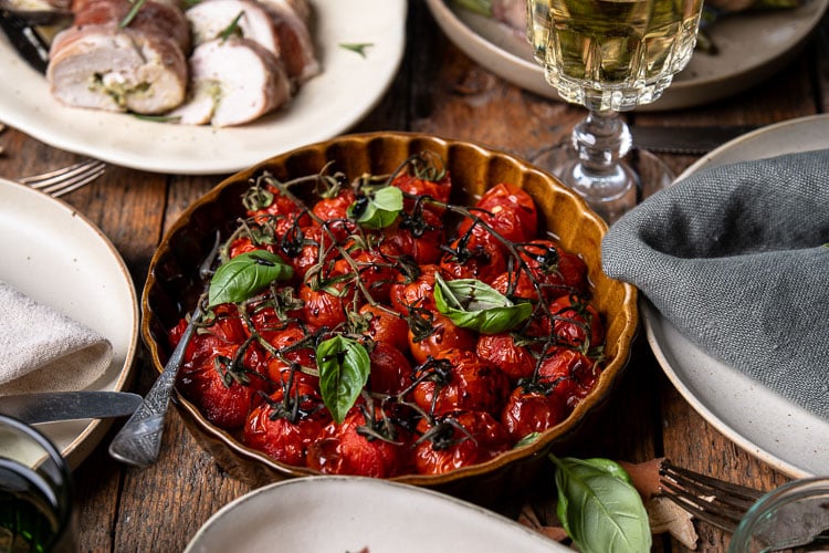 Geroosterde tomaatjes uit de oven; cherrytomaatjes met olijfolie, knoflook, balsamico en tijm, zacht en vol smaak gebakken als feestelijk groente bijgerecht voor Kerst.