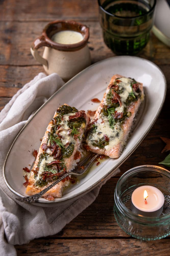 Gegaarde zalm uit de oven met pesto en krokante ham, sappig en zacht met romige wittewijnsaus.