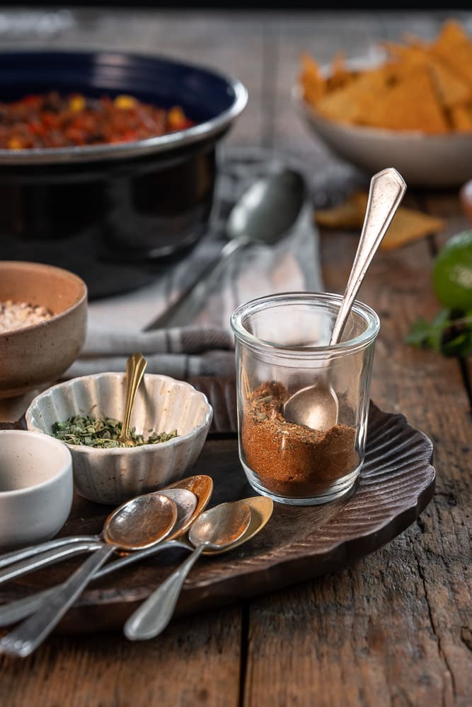 Zelfgemaakte chili con carne kruidenmix met komijn, paprikapoeder, oregano en chilipeper. Een makkelijke kruidenmix zonder pakjes of zakjes waarmee je chili con carne een kruidige, warme en licht pittige Mexicaanse smaak geeft.