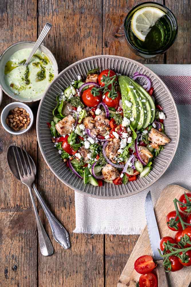 Kip pesto salade met avocado, feta, groenten en pesto dressing – gezonde lunch salade met kip.