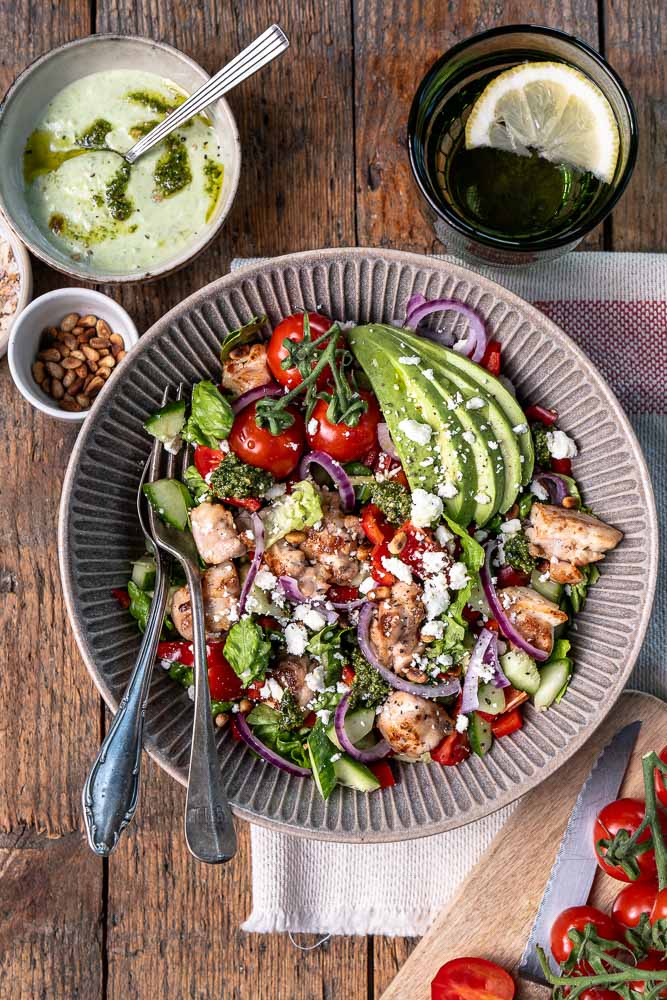 Kip pesto salade met avocado, feta, groenten en pesto dressing – gezonde lunch salade met kip.
