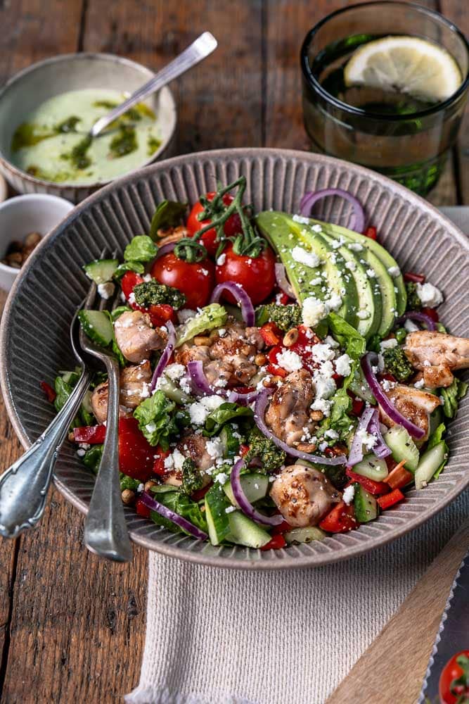 Kip pesto salade met avocado, feta, groenten en pesto dressing – gezonde lunch salade met kip.