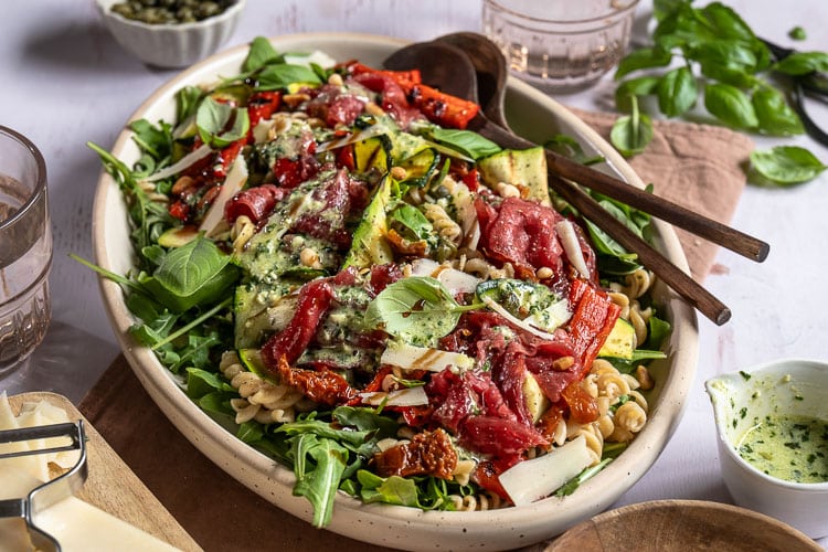 Carpaccio salade met volkoren pasta, gegrilde groenten, rucola, Parmezaanse kaas en pijnboompitten. Deze carpaccio salade kun je maken als maaltijdsalade of luxe lunch. Ook goed voor bijvoorbeeld een picknick!