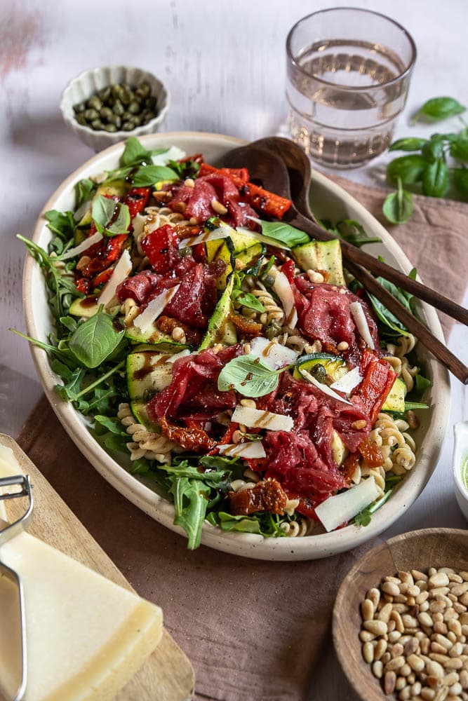 Carpaccio salade met volkoren pasta, gegrilde groenten, rucola, Parmezaanse kaas en pijnboompitten. Deze carpaccio salade kun je maken als maaltijdsalade of luxe lunch. Ook goed voor bijvoorbeeld een picknick!
