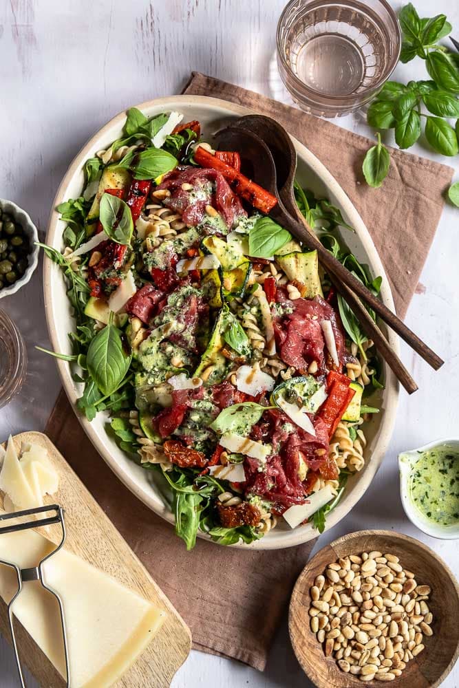 Carpaccio salade met volkoren pasta, gegrilde groenten, rucola, Parmezaanse kaas en pijnboompitten. Deze carpaccio salade kun je maken als maaltijdsalade of luxe lunch. Ook goed voor bijvoorbeeld een picknick!