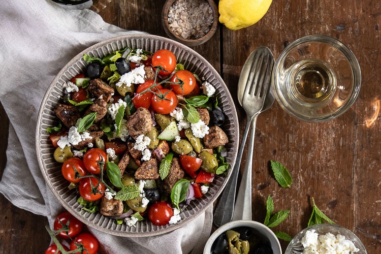 Griekse salade met gemarineerde kip, feta, knapperige rauwkost en zelfgemaakte yoghurtdressing. Heerlijk als lichte lunch of Griekse maaltijdsalade.