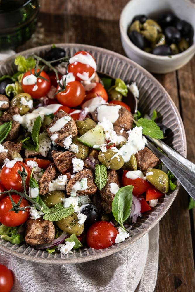Griekse salade met kip, feta, groenten en yoghurtdressing