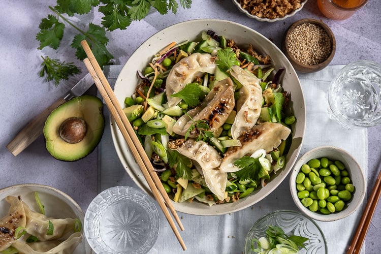 Frisse gyoza salade met kip gyoza, koolmix, edamame, avocado, komkommer, paprika en een Oosterse dressing. Makkelijke maaltijdsalade voor lunch of avondeten.