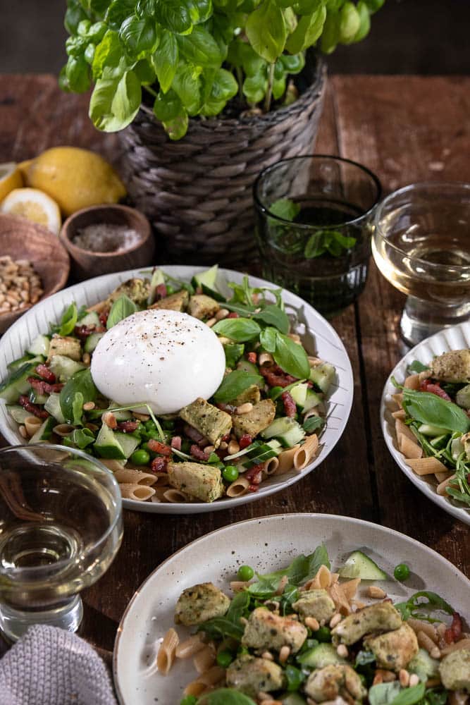 Pastasalade met kip, volkoren pasta, burrata, pesto, spekjes, rucola en doperwten. Makkelijke Italiaanse maaltijdsalade voor lunch of avondeten.