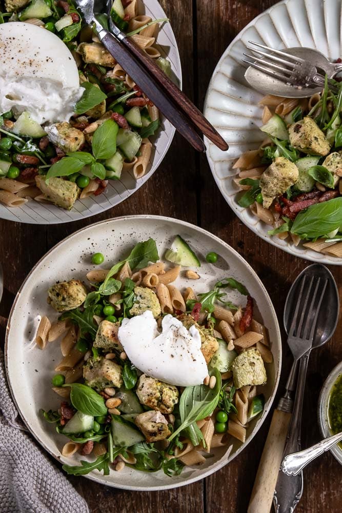 Pastasalade met kip, volkoren pasta, burrata, pesto, spekjes, rucola en doperwten. Makkelijke Italiaanse maaltijdsalade voor lunch of avondeten.
