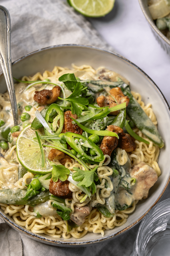Romige Thaise groene curry met kip, noedels en groene groenten
